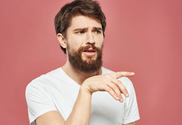 istock bearded man showing thumb to the side on pink background cropped view Copy Space 2151107935