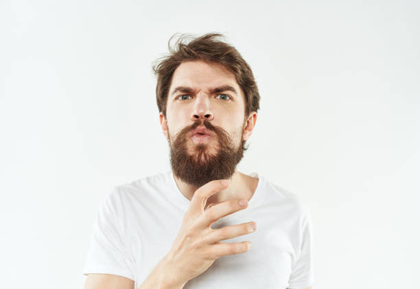 A young man in a white T-shirt gestures with his hands emotions irritability stress. High quality photo