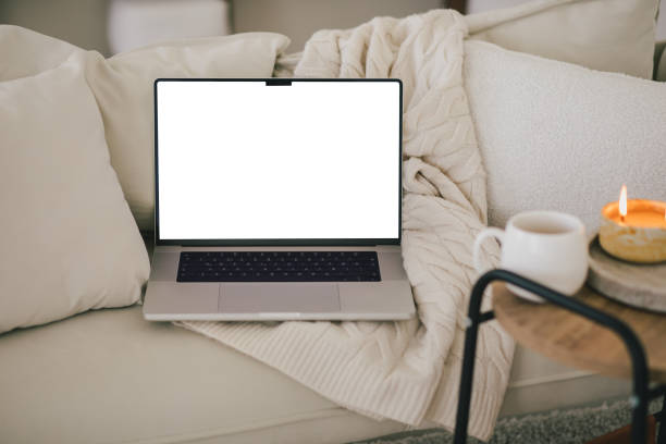 istock Laptop and white mug with tea on a sofa. Workspace in a modern room. 2151114049