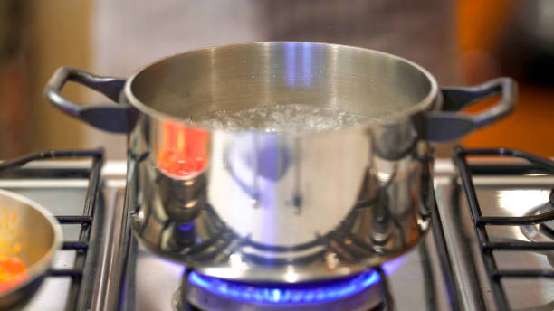 istock Professional chef cooking in domestic kitchen: Boiling water for tomato spaghetti preparation 2151120810