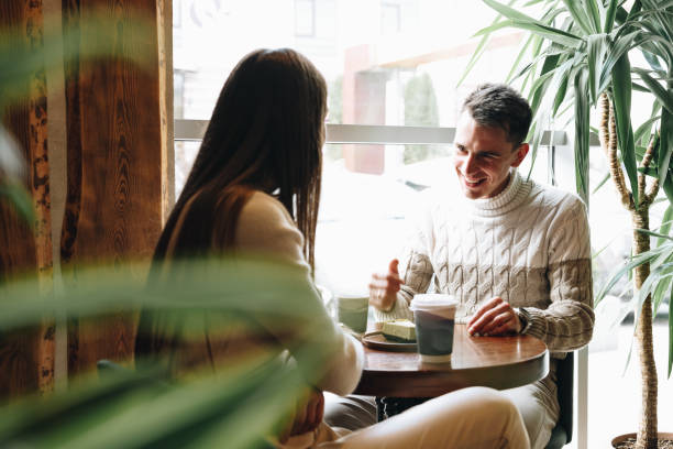 istock Man and Woman Sitting at Table Talking 2151120851