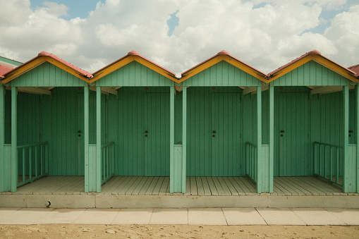 Green cabins on the beach at the sea. Vintage look.