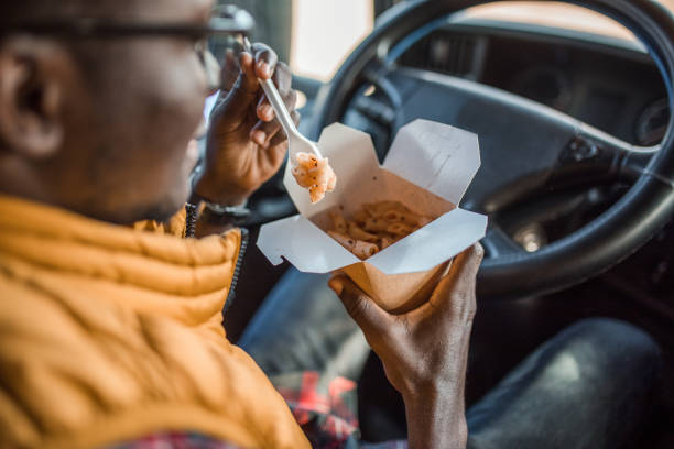 istock Unrecognizable male truck driver eating pasta in the driver's seat 2151127708