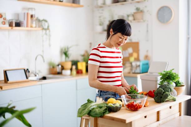 istock Woman cutting vegetables 2151129516