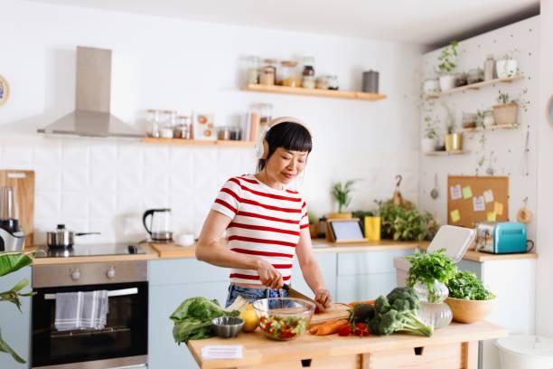 istock Woman enjoying in her kitchen while preparing vegan food 2151129621