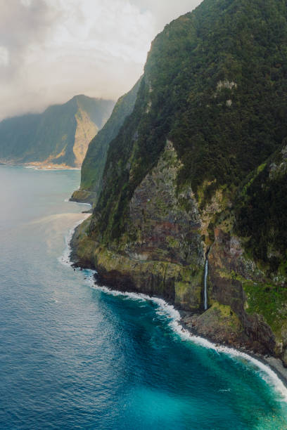 istock Dramatic Aerial View of Waterfall Falling From Mountains Into Ocean on Madeira Island 2151129886