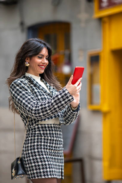 istock Woman using smartphone outdoors in the city at sunset 2151134594