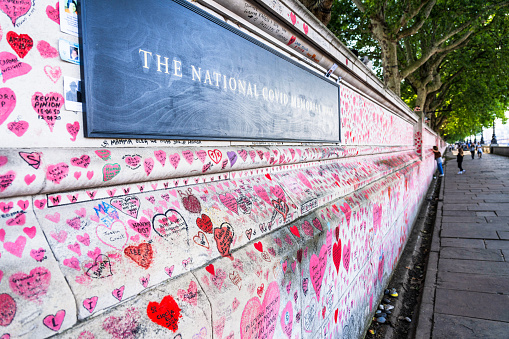 A view along part of the National Covid Memorial Wall, by the Thames in Westminster, London. The wall is decorated with thousands of red hearts and personal dedications to the victims of the Covid-19 pandemic in the UK.