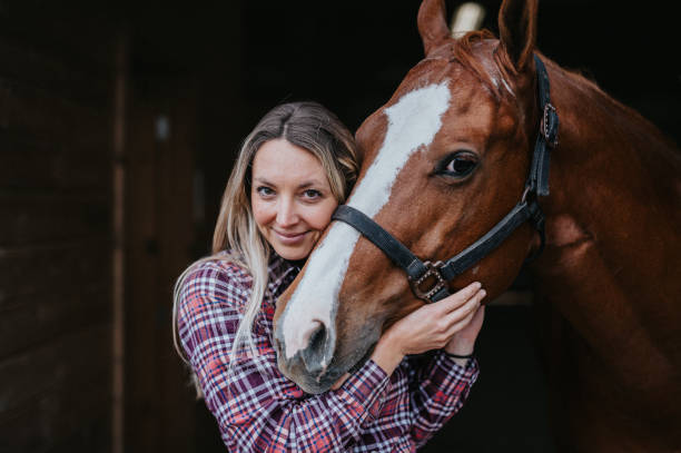 istock Woman smiles while being affectionate with her horse 2151139295