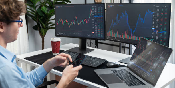 istock Young investor looking on smartphone surrounded current market screen. Gusher. 2151142232