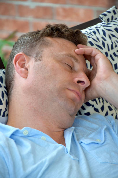 Tired mid adult woman yawning before going to sleep in a bed.