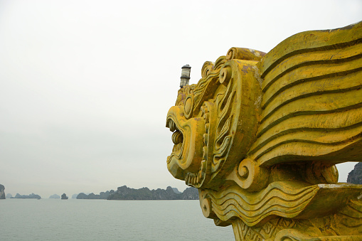 Bái Tử Long: side view of a figurine dragon head looking over the panoramic Tu long bay.
