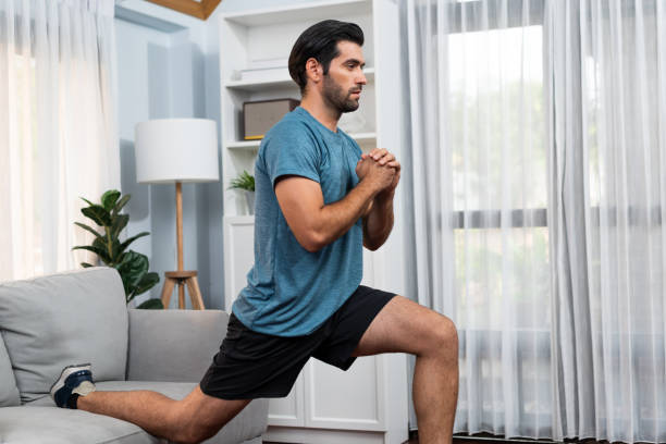 istock Athletic and sporty man doing squat at gaiety home exercise. 2151149205