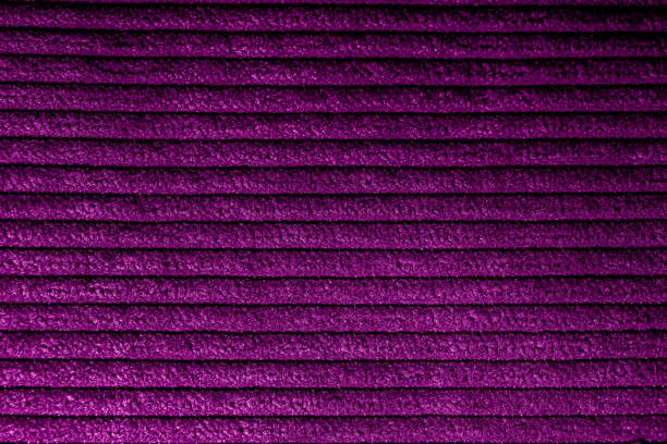 Closeup of magenta corduroy cloth as patterned textured background for design purpose