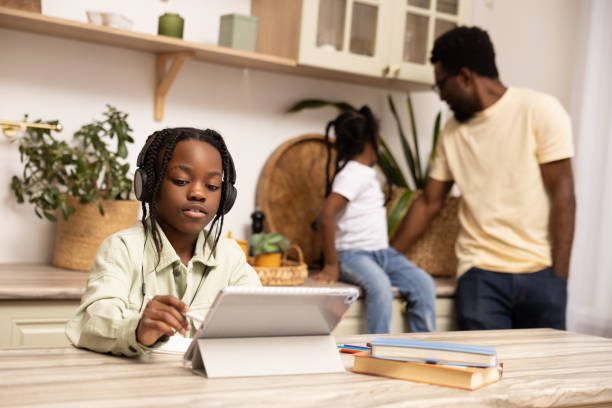 istock Multicultural little girl using digital software on tablet for online education 2151153000