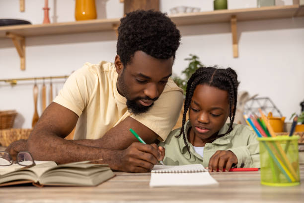 istock Smiling African American dad doing homework during homeschooling time 2151153017