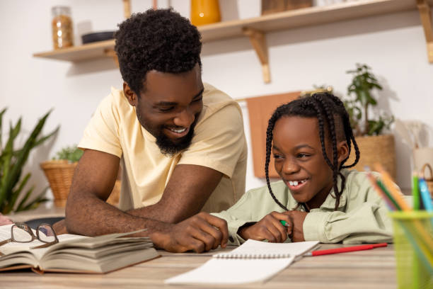 istock Young multiethnic father helping his daughter with her homework 2151153033