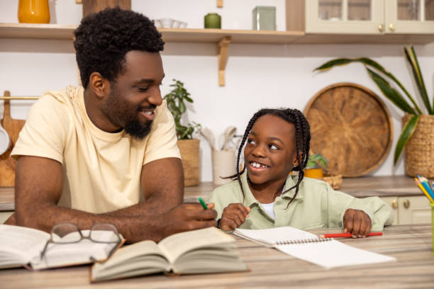 istock Smiling African American dad doing homework during homeschooling time 2151153037