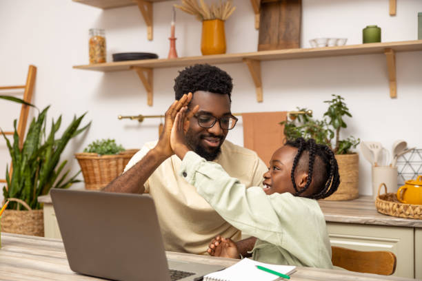 istock Black father with daughter doing online tasks on laptop 2151153104