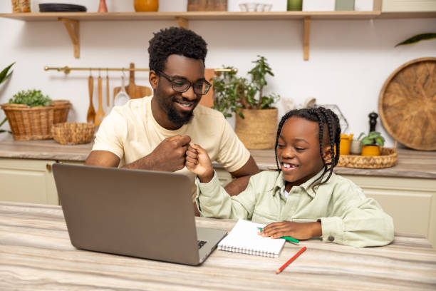istock Father with schoolgirl daughter using laptop for doing homework during remote studying 2151153105