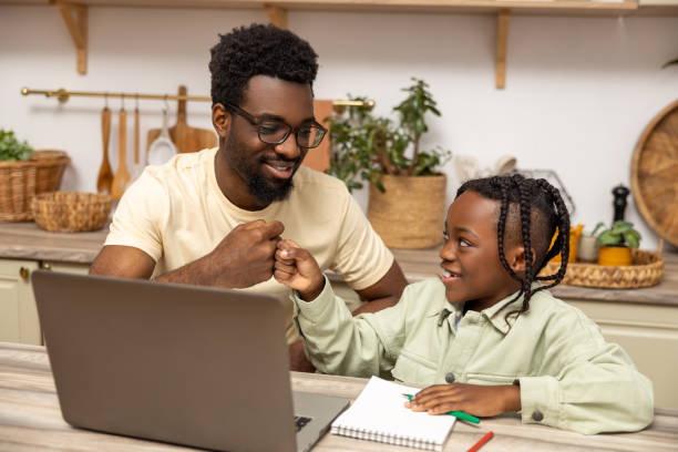 istock Father with schoolgirl daughter using laptop for doing homework during remote studying 2151153115