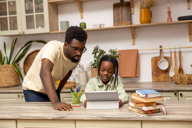 istock Multicultural father and little girl doing school tasks together using tablet 2151153134