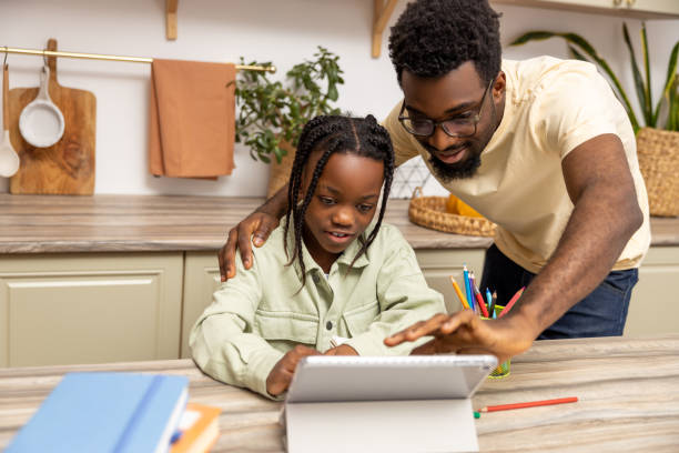 istock Multicultural father and little girl doing school tasks together using tablet 2151153138