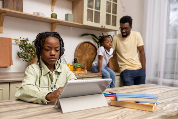istock Black little girl taking class online using digital tablet 2151153149