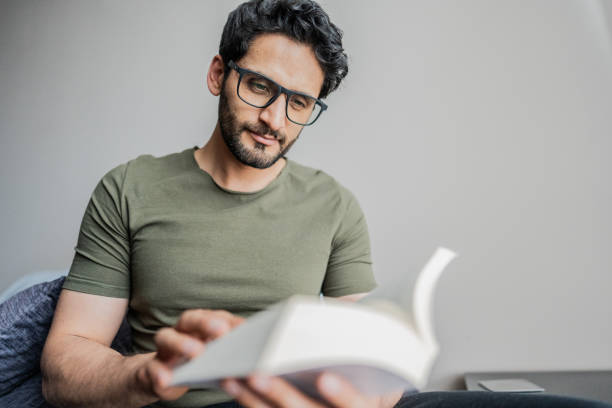 Mid adult man reading a book at home