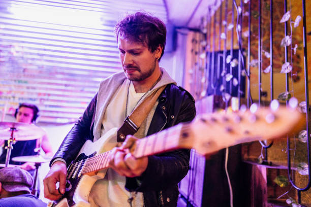 Mid adult man playing eletric guitar on a rock show