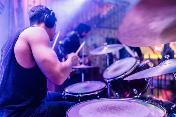 Mid adult man playing drum kit on a rock show