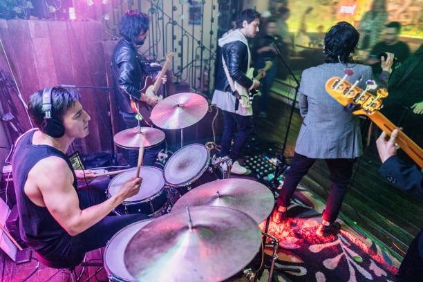 Mid adult man playing drum kit on a rock show