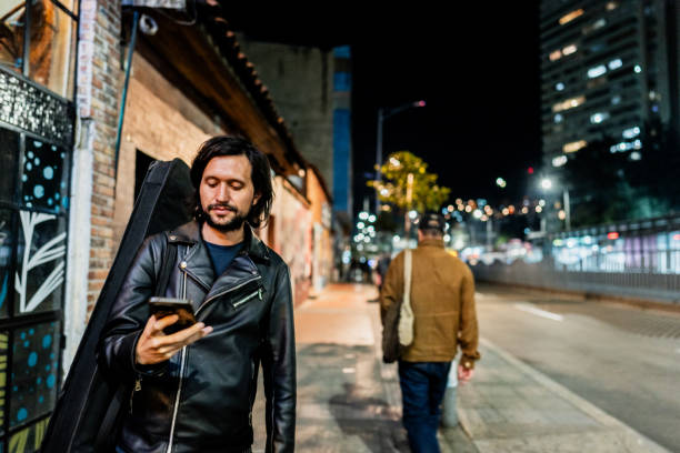 Young man using mobile phone and walking around the city