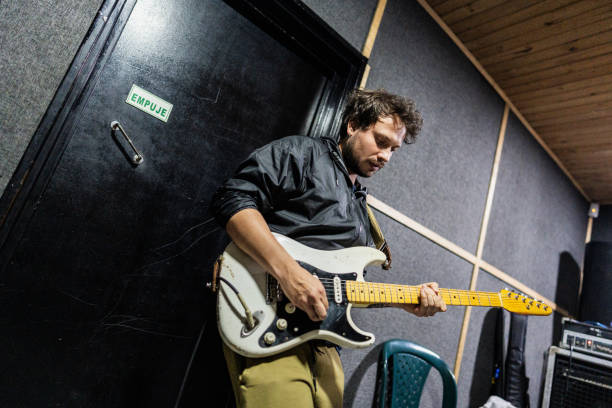 istock Mid adult man playing guitar at recording studio 2151160187