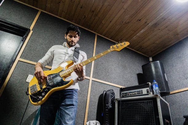 istock Mid adult man playing guitar at recording studio 2151160264