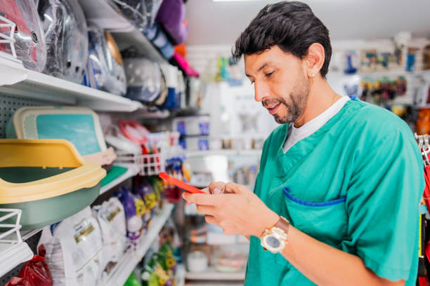 istock Mature veterinarian man using mobile phone in a pet shop 2151161306