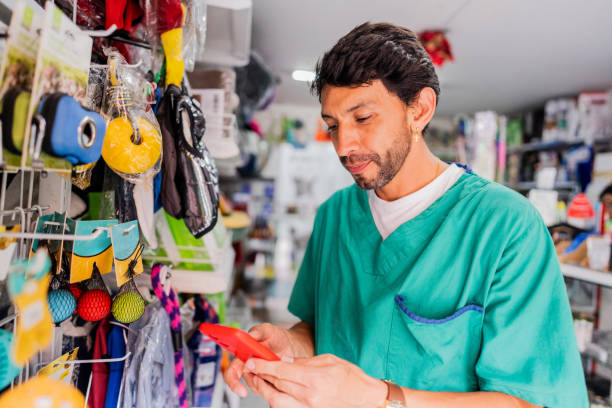 istock Mature veterinarian man using mobile phone in a pet shop 2151161398