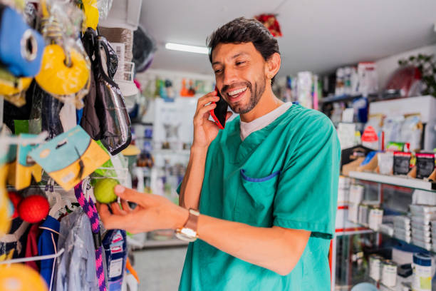 istock Mature veterinarian man using mobile phone in a pet shop 2151161399