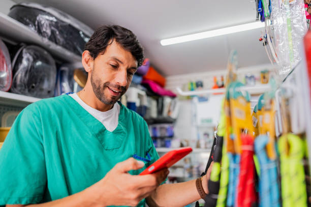 istock Mature veterinarian man using mobile phone in a pet shop 2151161402