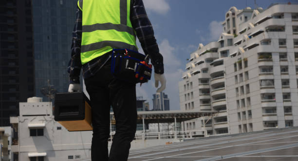 Solar panel technician with toolbox installing solar panels on the roof, electrician panel sun sustainable resources renewable energy source alternative innovation.
