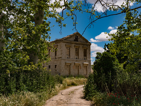 Ruined and abandoned house, sunny day with clouds