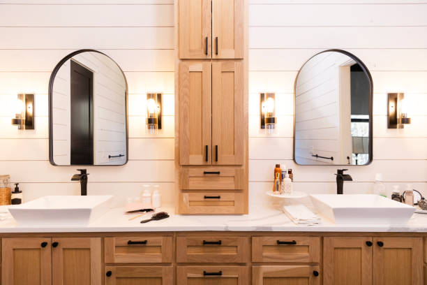 Newly renovated modern bathroom in luxury home Photo of a recently renovated modern bathroom with shiplap walls and natural wood cabinetry in a family home. light fixture stock pictures, royalty-free photos & images