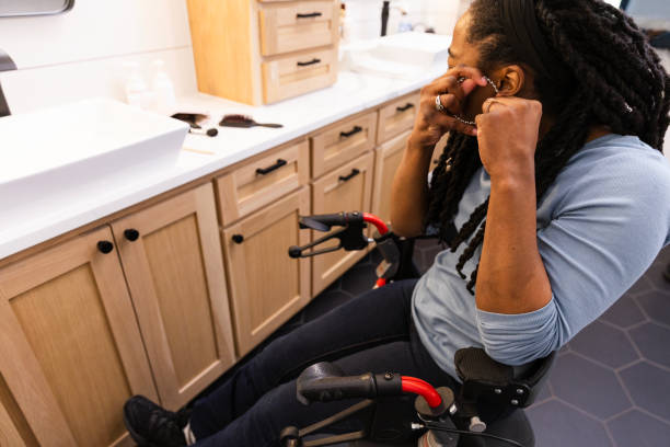 istock Woman sitting on rollator in bathroom puts on earrings 2151164795