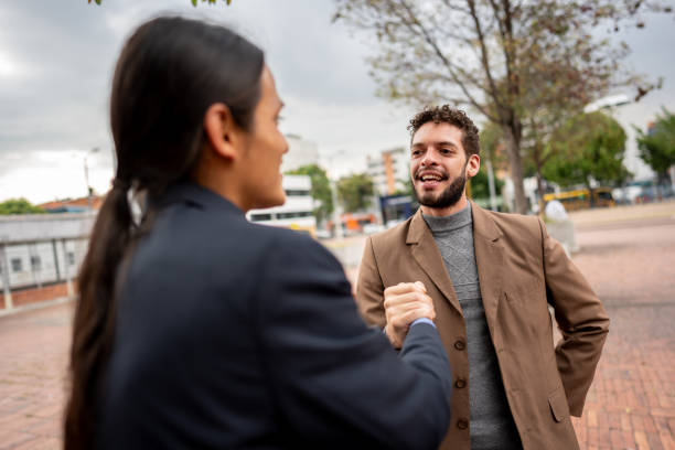 istock Coworkers greeting each other outdoors 2151168030