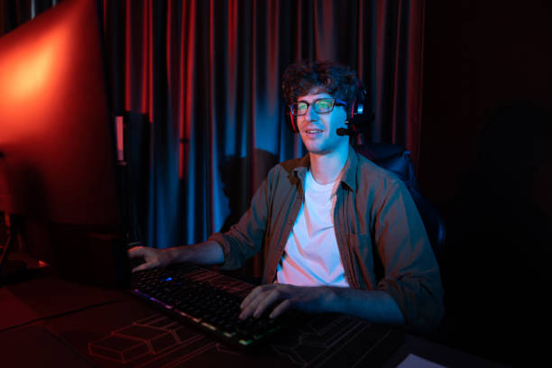 istock Smiling streamer with joystick, focusing Esport team on pc with harder. Gusher. 2151168110