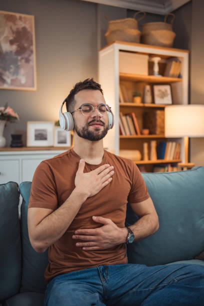 istock A young man with headphones sits on a bed and practices guided meditation 2151169415