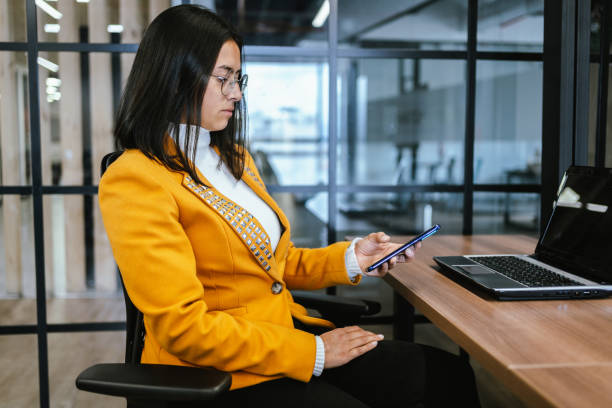istock Young businesswoman using mobile phone at office 2151172287