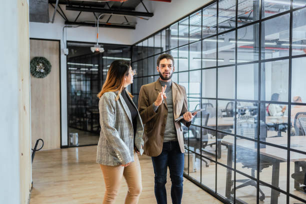 istock Coworkers talking and walking in the office hallway 2151172337