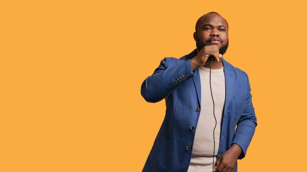 istock Energetic musician singing to imaginary crowd, doing karaoke, studio background 2151174057