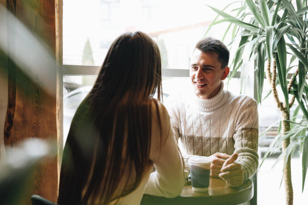 istock Man and Woman Sitting at Table Talking 2151174112